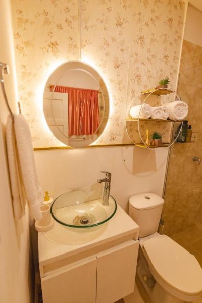 Baño moderno con lavabo de cristal y espejo LED retroiluminado en Casa Hadasa