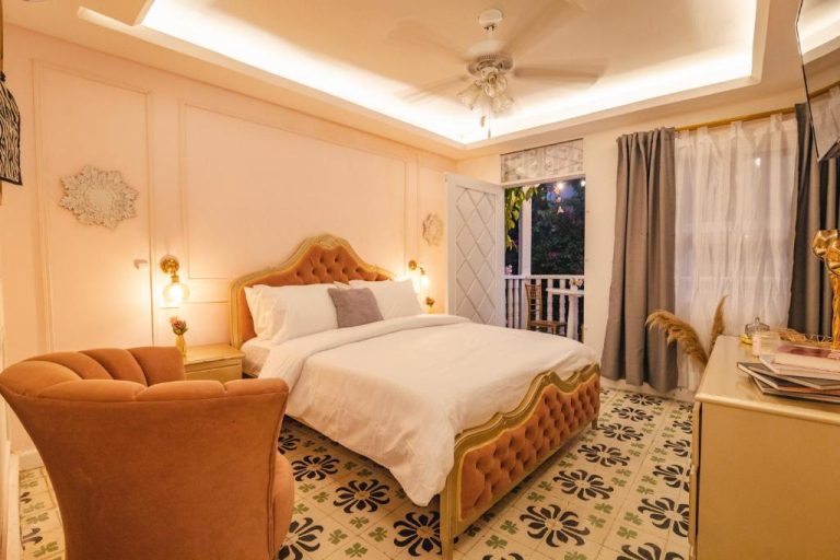 Habitación romántica con cama tapizada dorada y suelo de mosaico en Casa Hadasa