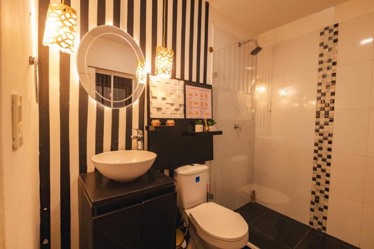 Baño moderno con ducha de cristal y decoración en blanco y negro en Casa Hadasa
