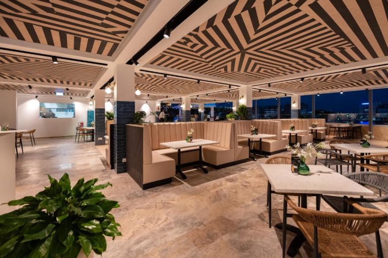 Restaurante con terraza panorámica y elegantes booth del Harbor Hotel & Casino Curacao con vistas nocturnas
