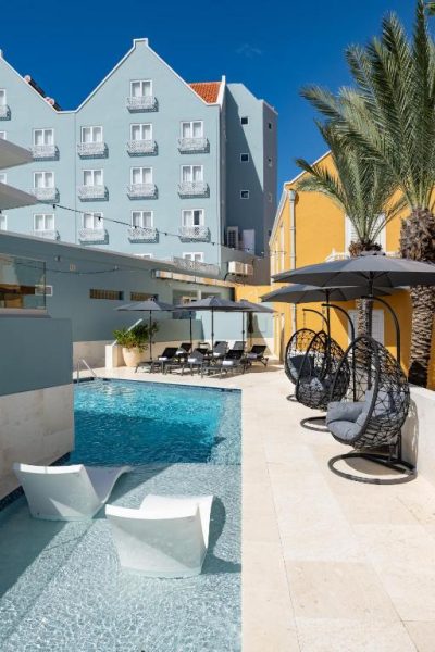 Piscina exterior con tumbonas y sillas colgantes del Harbor Hotel & Casino Curaçao