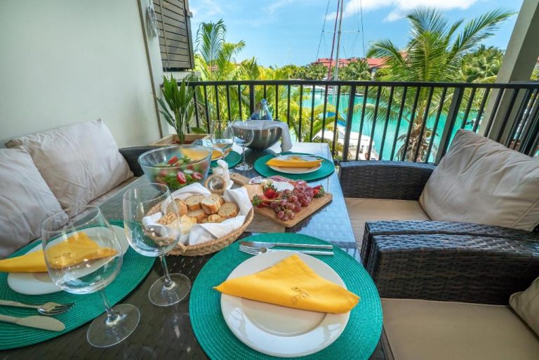 Terraza con mesa servida y vistas a la marina en Eden Island Self Catering Apartment, Seychelles