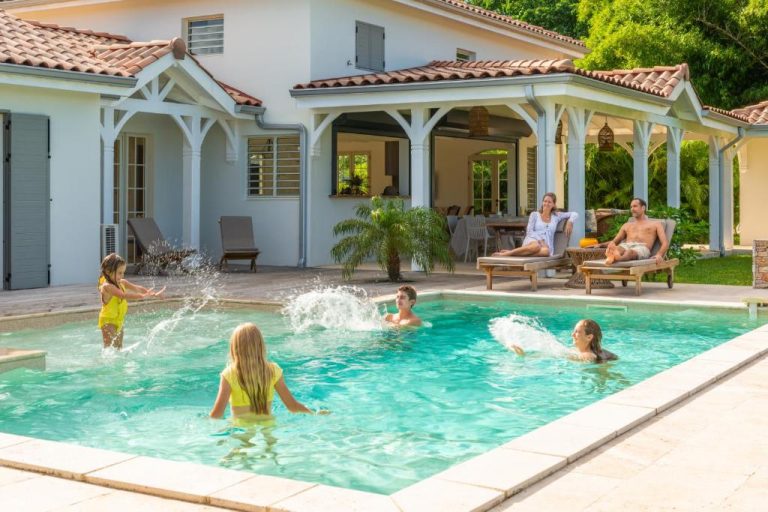 Familia disfrutando de la piscina privada exterior del Habitation Saint Charles Hôtel de Charme & Spa