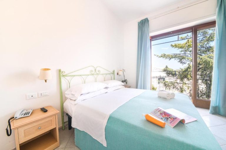 Habitación doble con cama y vistas al exterior en Hotel Europa, decoración en tonos azules y blancos