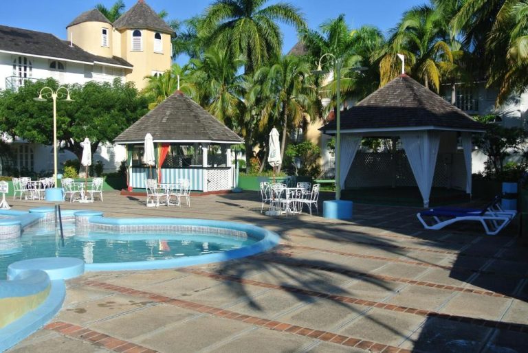 Piscina exterior con gazebos y terraza del Beach Studio 9 rodeada de palmeras tropicales