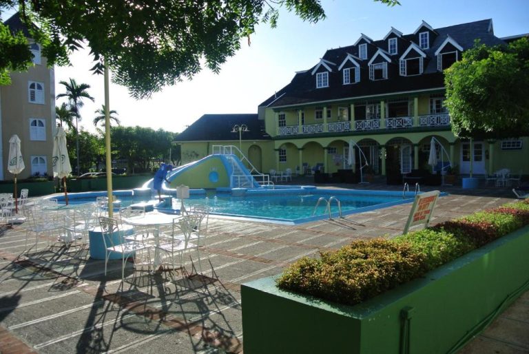 Piscina exterior con tobogán acuático y zona de relax en Beach Studio 9 Jamaica