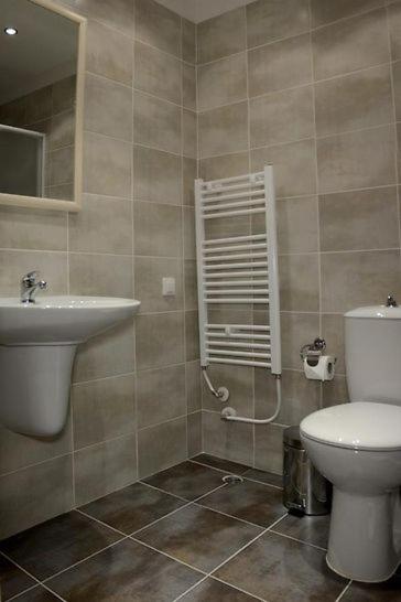 Baño moderno con ducha, lavabo y toallero eléctrico en Park Hotel Kyustendil Bulgaria