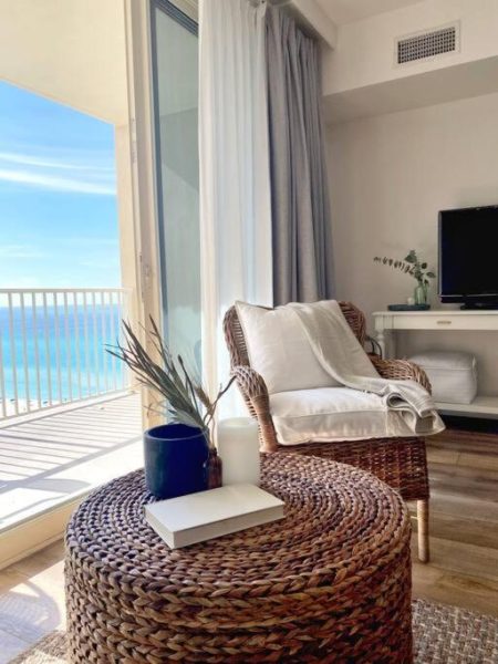 Salón con sillón de ratán y vista panorámica al mar desde el apartamento 1209 de Shores of Panama