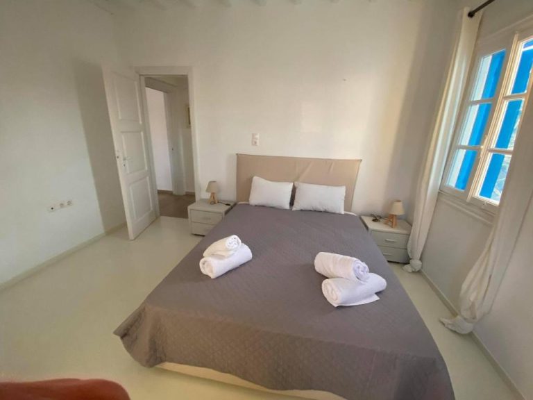 Habitación doble con cama matrimonial y toallas en Fabrica Sunset Apartments con ventana luminosa