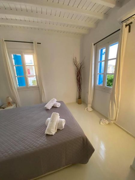 Habitación doble luminosa con cama matrimonial y toallas en Fabrica Sunset Apartments
