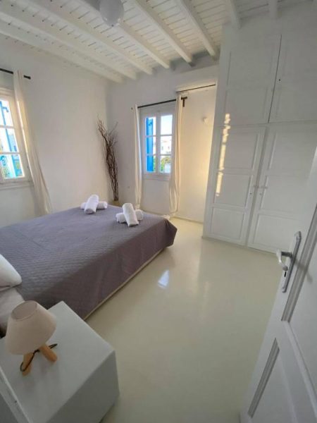 Habitación doble con decoración blanca y toallas en Fabrica Sunset Apartments en Mykonos