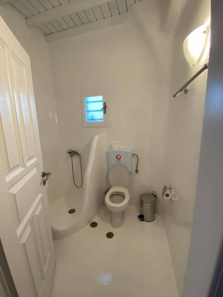 Baño completo blanco con ducha y aseo integrados en Fabrica Sunset Apartments