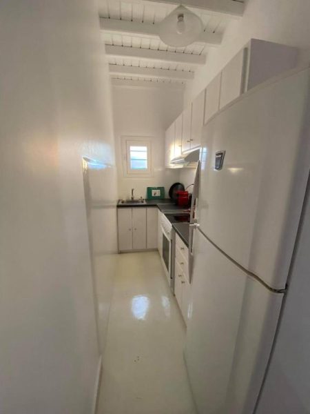 Cocina totalmente equipada con nevera y electrodomésticos blancos en Fabrica Sunset Apartments