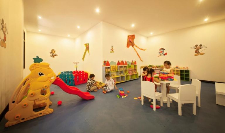 Sala de juegos infantiles con tobogán y mesa de actividades en Hoi An Historic Hotel