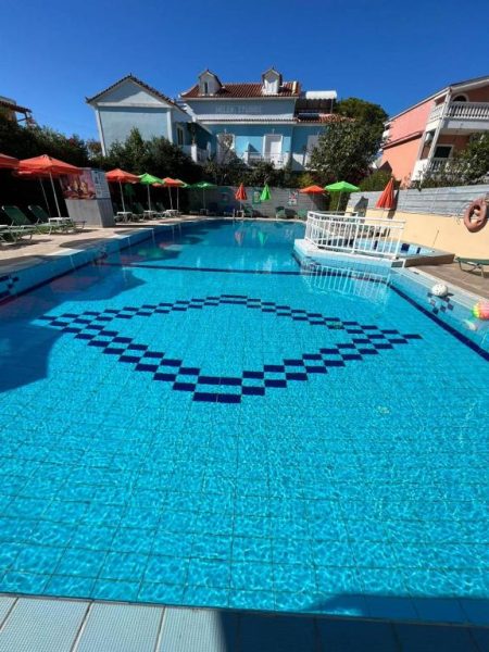Piscina exterior de aguas cristalinas con mosaico decorativo en Trenta Nove Studios, Grecia
