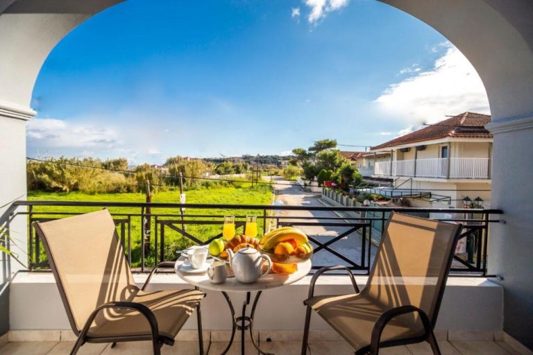 Terraza con desayuno y vistas al jardín en Trenta Nove Studios, mesa con frutas y zumo