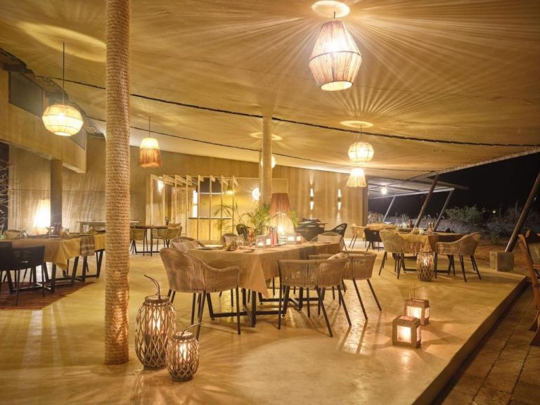 Restaurante con terraza iluminada y ambiente íntimo del Surana Buffalo Springs con decoración rústica natural