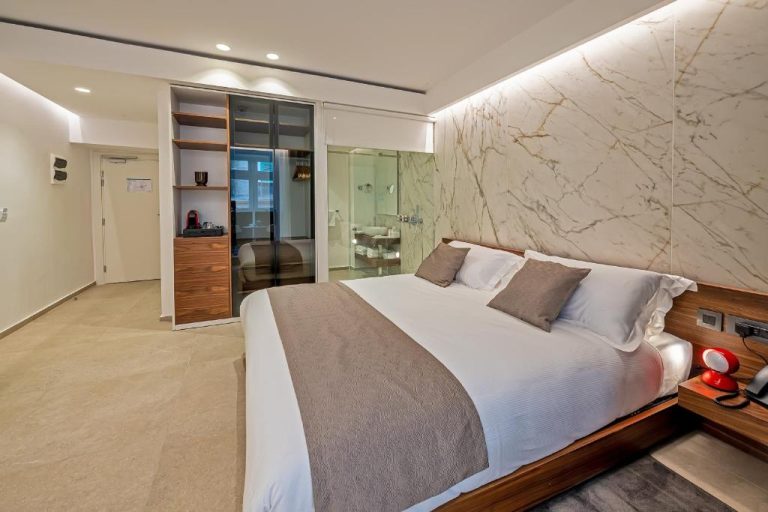 Suite de lujo con pared de mármol y baño de cristal en The Capital Boutique Hotel