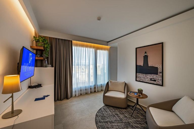 Salón moderno con sofá, televisión y vistas en The Capital Boutique Hotel