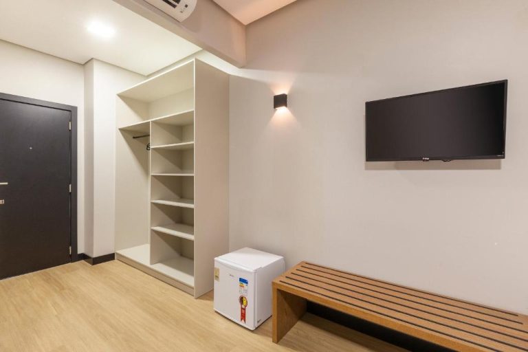 Habitación con armario empotrado, minibar y televisión de pared en Tri Hotel Antônio Prado