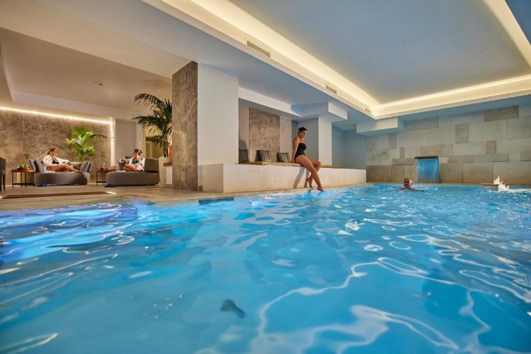 Piscina interior climatizada con zona de relax y cascada de agua en el Hotel Palazzo Doglio