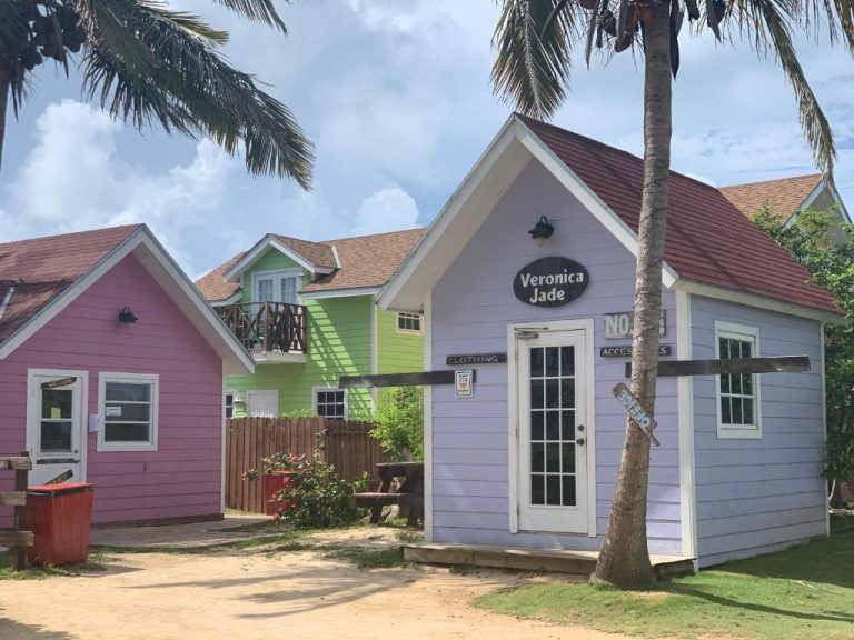 Cabañas coloridas de madera en el exterior del Bay Inn Estates rodeadas de palmeras tropicales