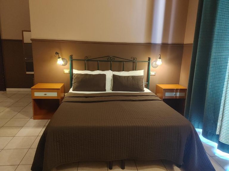 Habitación doble con cama matrimonial y mesitas de noche en Hotel Biscari