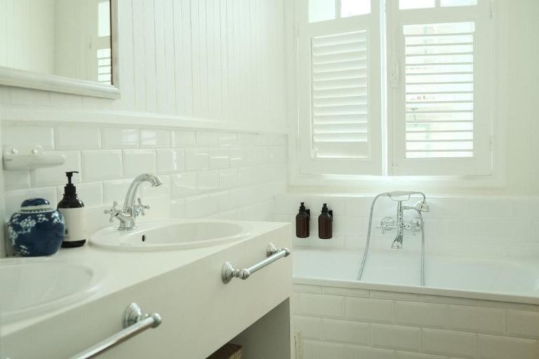 Baño elegante con bañera blanca y lavabo doble en Maison Victoire Boutique Hôtel Pointe-à-Pitre