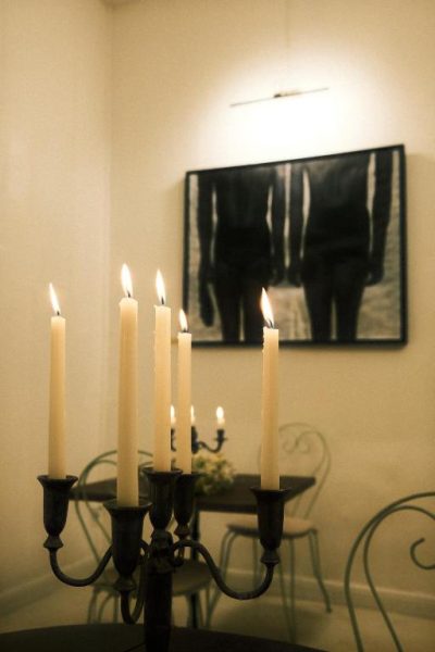 Candelabro con velas encendidas y cuadro de arte en el salón del Maison Victoire boutique hôtel Pointe-à-Pitre