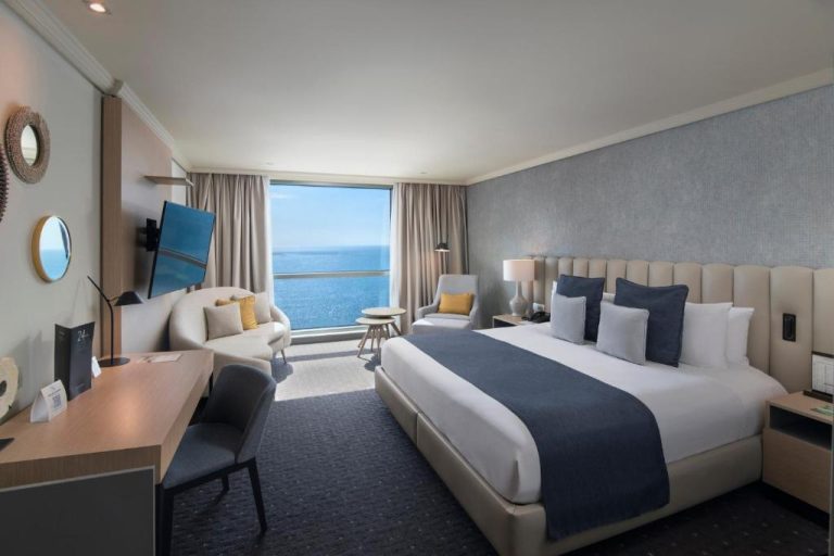 Habitación deluxe con cama king size y vistas al mar en el Hotel Catalonia Santo Domingo