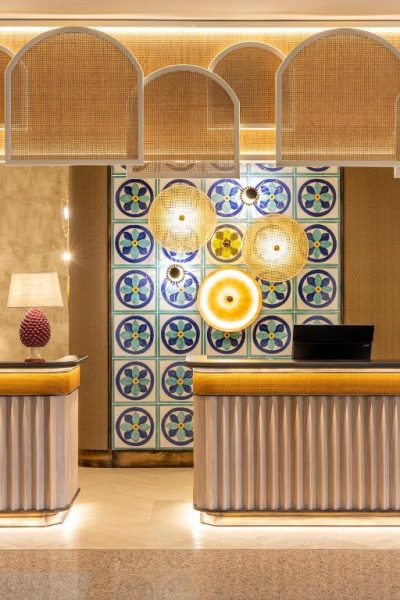 Recepción elegante del Delta Hotels by Marriott Giardini Naxos con azulejos decorativos y lámparas doradas