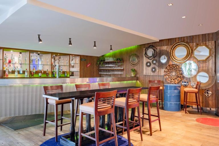 Bar lounge elegante con taburetes y estantería de bebidas en el Marriott Marquis City Center Doha