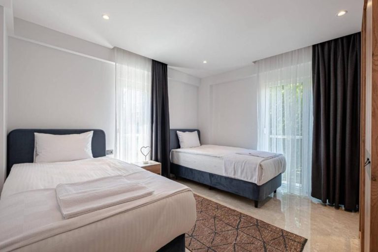 Habitación twin con dos camas individuales y ventanales en Belek Deluxe Suit