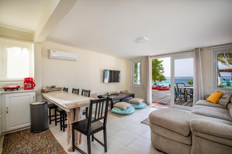 Sala de estar con comedor y terraza con vistas al mar en Serene by the Sea