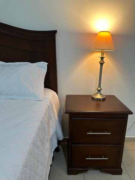 Habitación con cama doble y mesita de noche iluminada en Hotel Real Paraíso