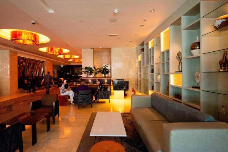 Elegante lobby lounge del Sheraton Athlone Hotel con sofás, estanterías decorativas e iluminación cálida