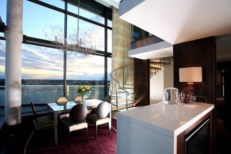 Suite dúplex con comedor elegante y vistas panorámicas al atardecer en Sheraton Athlone Hotel