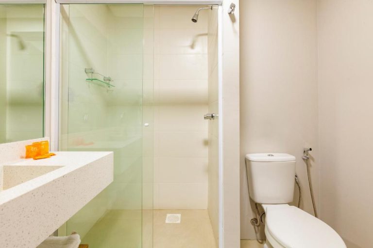 Baño moderno con ducha de cristal y sanitarios blancos en Tri Hotel Antônio Prado