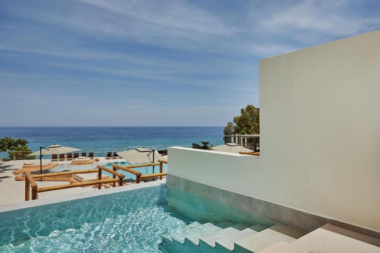 Piscina infinita con vistas al mar Mediterráneo y tumbonas en Tsamis Zante Suites
