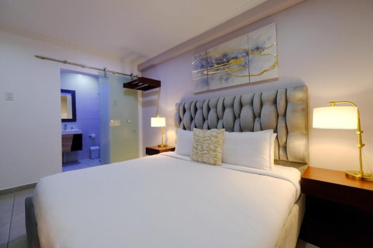 Habitación doble con elegante cabecero tapizado y baño en suite del Victoria City Hotel