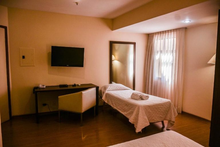 Habitación doble con camas individuales, escritorio y TV en Mont Blanc Apart Hotel Nova Iguaçu