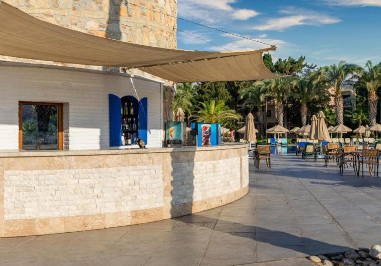 Bar exterior junto a la piscina del Selectum Collection Bodrum con terraza y palmeras