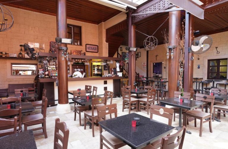 Bar y restaurante interior del Cicerone Lodge Hotel con mesas de granito y ambiente rústico