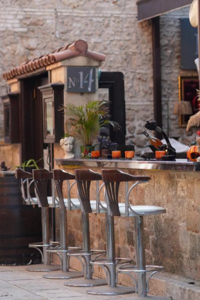 Terraza bar exterior con taburetes altos y barra de piedra del Cicerone Lodge Hotel