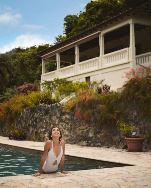 Mujer disfrutando de la piscina exterior rodeada de jardines tropicales en Casa Grande Mountain Retreat Adults Only