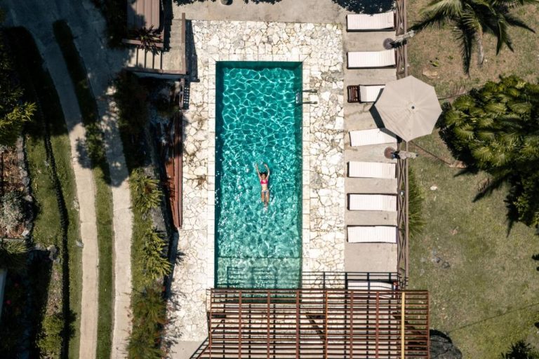 Vista aérea de la piscina exterior con tumbonas y sombrillas del Casa Grande Mountain Retreat Adults Only
