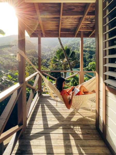 Mujer leyendo en hamaca en la terraza con vistas a la selva del Casa Grande Mountain Retreat Adults Only