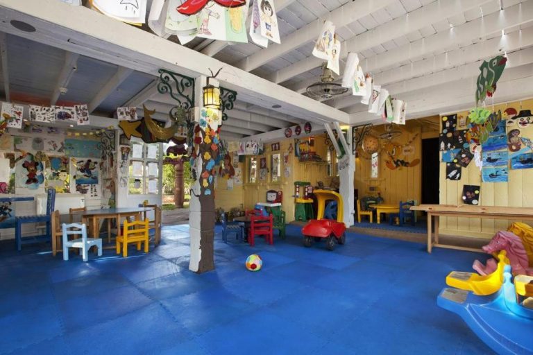 Sala de juegos infantil colorida con coches de juguete y manualidades en Hotel Studio