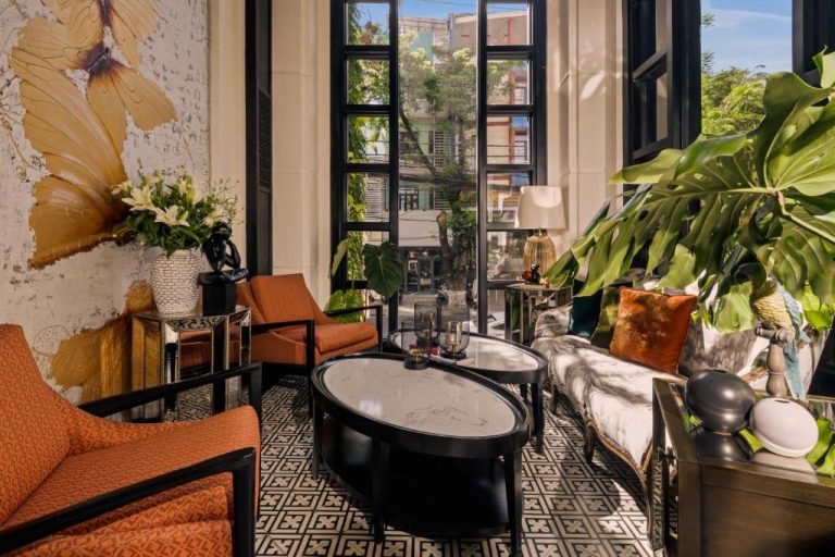 Elegante salón colonial con sofás y plantas tropicales en el Sanouva Da Nang Hotel de Vietnam