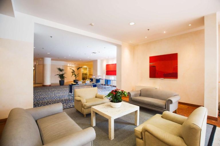 Elegante sala de espera con sofás y mesa de mármol en el lobby del Hilton Rome Airport